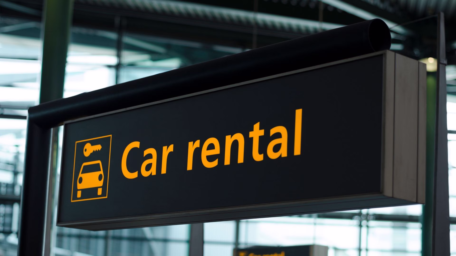 A car rental sign hanging in an airport terminal